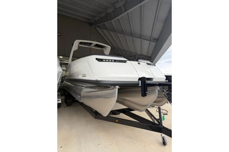 Slide: The Image of 2026 Harris Crowne 250 pontoon boat in a covered storage area. - 5