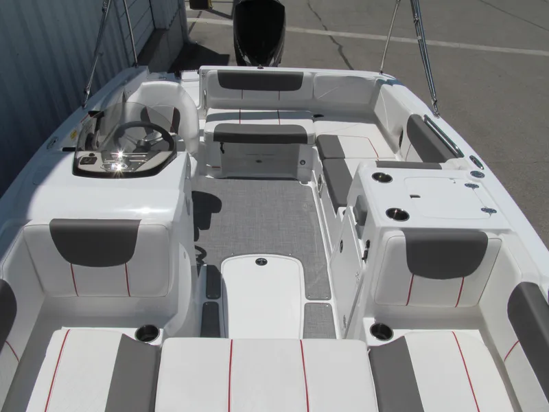 Slide: The Image of 2023 Tahoe 2150 boat interior with gray and white seating, cup holders, and steering console. - 13