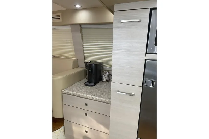Slide: The Image of Interior of 2008 Sea Ray 47 Sedan Bridge yacht with modern cabinetry and coffee maker. - 15