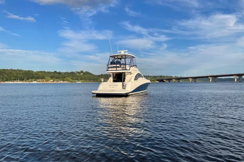 Slide: The Image of 2008 Sea Ray 47 Sedan Bridge yacht on calm water near a bridge. - 20