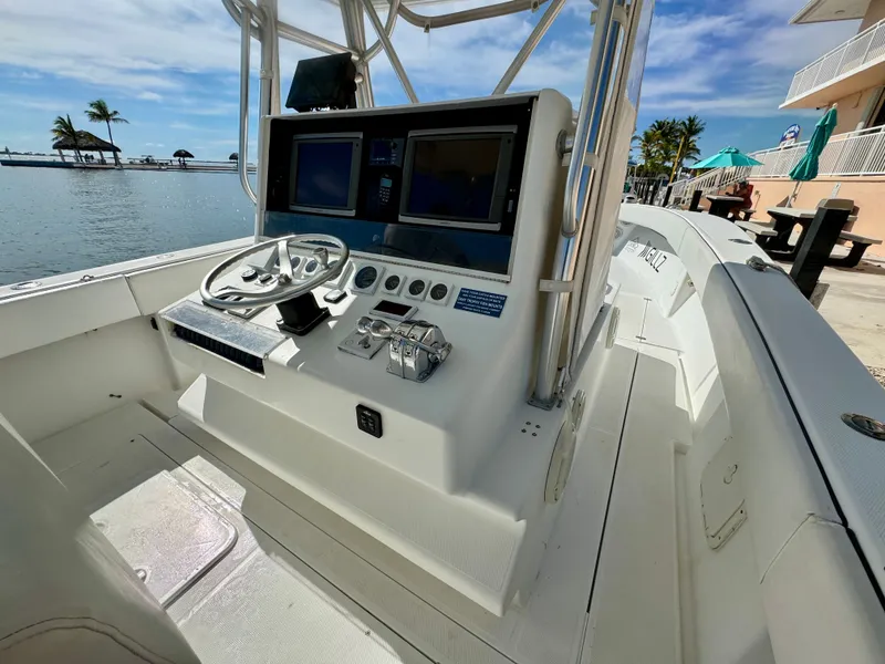 Slide: The Image of Helm of a 2000 SeaVee 340i boat by the water. - 22