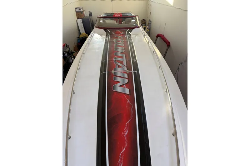 Slide: The Image of 2006 Fountain 42 Lightning boat with bold red and black graphics in a garage setting. - 13