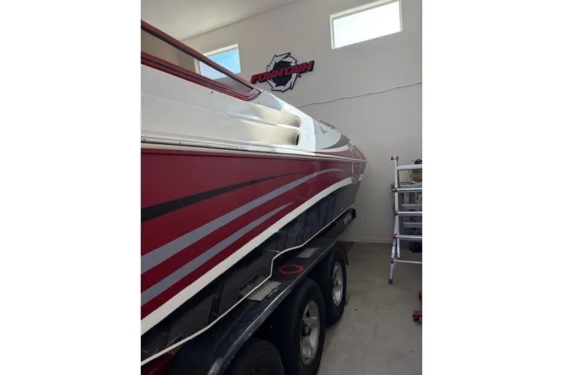 Slide: The Image of 2006 Fountain 42 Lightning boat in garage, red and white design, on trailer. - 6