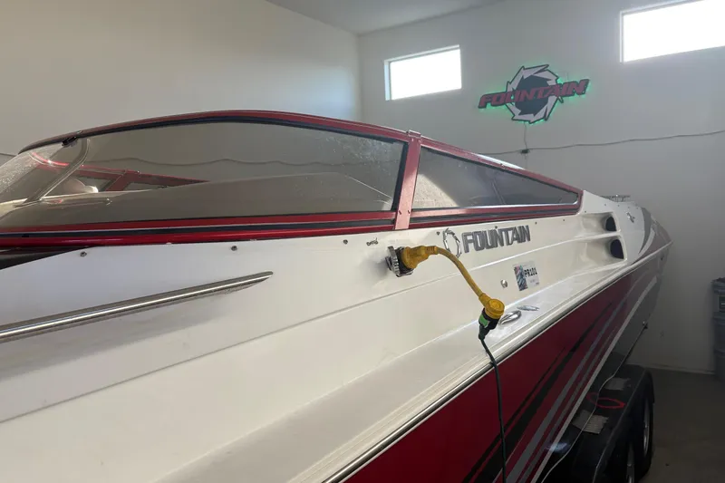 Slide: The Image of 2006 Fountain 42 Lightning boat in garage, red and white design, side view. - 9