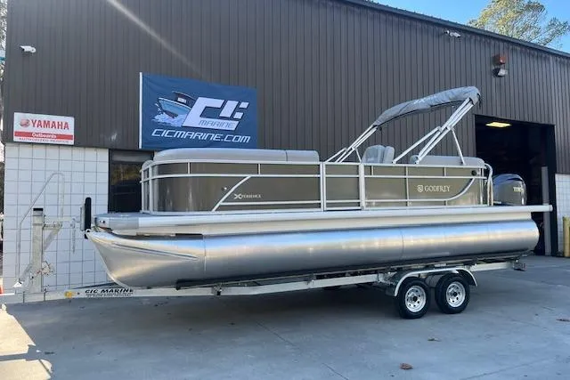 The Image of 2026 Godfrey EX 2286 SBX pontoon boat on trailer outside marine shop. - 2