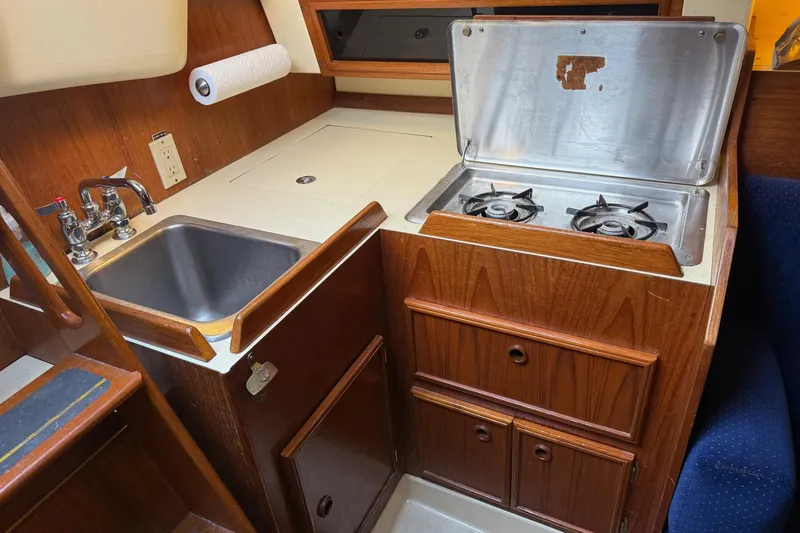 Slide: The Image of Compact kitchen area in a 1986 Pearson 303 sailboat with stove and sink. - 10