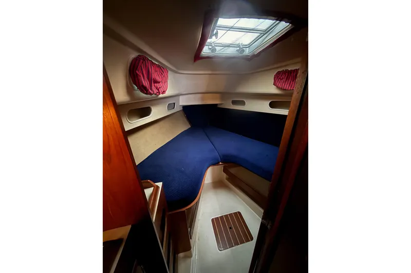 Slide: The Image of Interior cabin of 1986 Pearson 303 sailboat with blue cushions and overhead hatch. - 12