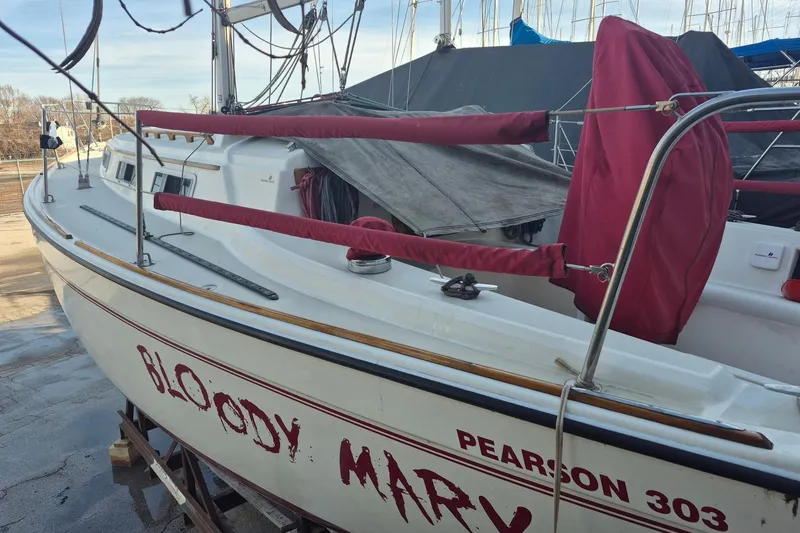 Slide: The Image of 1986 Pearson 303 sailboat named "Bloody Mary" docked with red covers. - 16