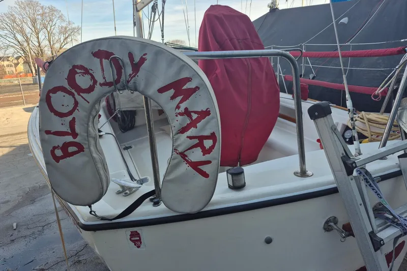 Slide: The Image of 1986 Pearson 303 sailboat with "Bloody Mary" life preserver on deck. - 18