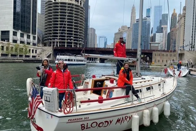 Slide: The Image of Group on 1986 Pearson 303 sailboat "Bloody Mary" in urban waterway, city skyline background. - 3