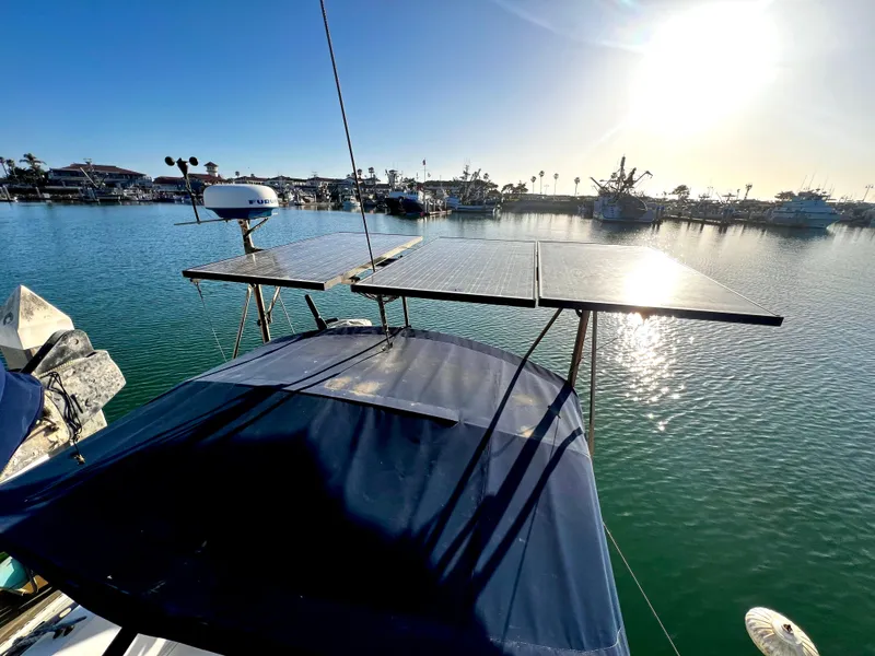 Slide: The Image of 1981 Cheoy Lee Golden Wave yacht with solar panels, docked in a sunny marina. - 11