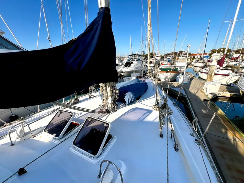 Slide: The Image of 1981 Cheoy Lee Golden Wave sailboat docked in a marina, clear blue sky. - 14