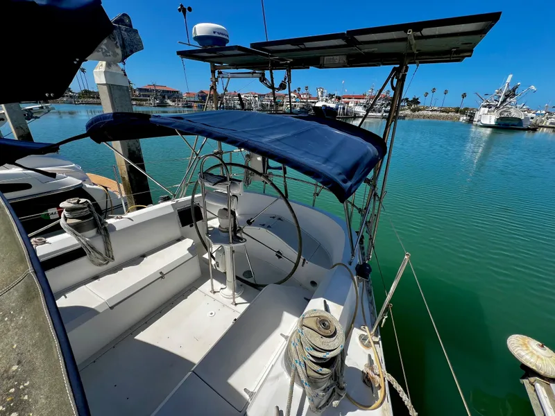 Slide: The Image of 1981 Cheoy Lee Golden Wave yacht docked in a marina, featuring a blue canopy and steering wheel. - 16
