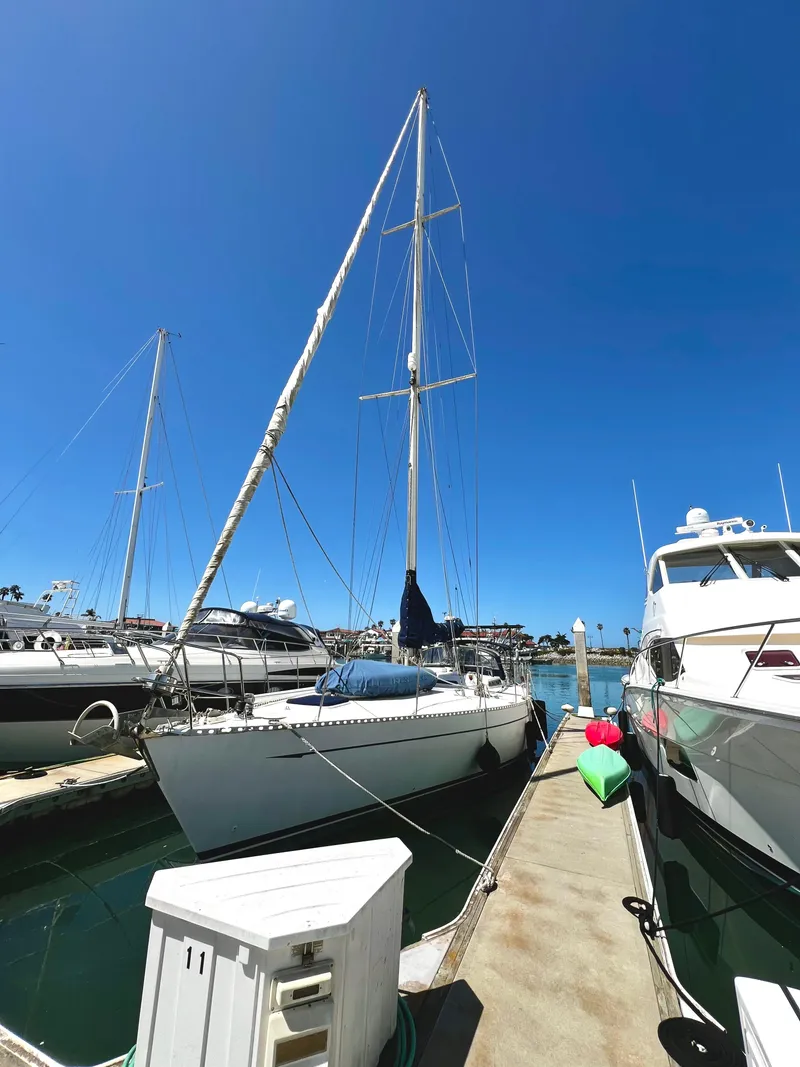 Slide: The Image of 1981 Cheoy Lee Golden Wave sailboat docked in a sunny marina. - 2