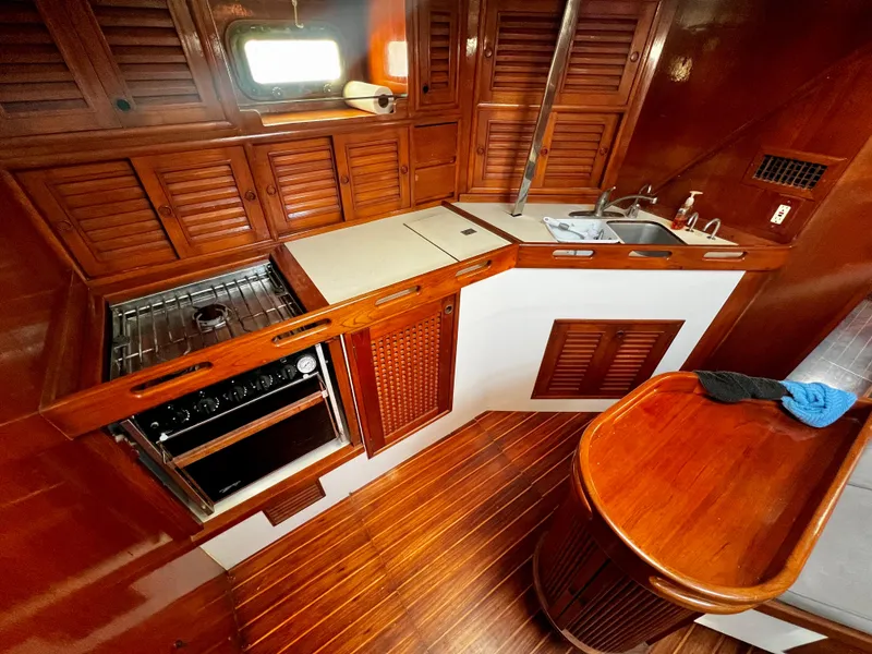 Slide: The Image of 1981 Cheoy Lee Golden Wave yacht kitchen with wooden cabinetry, stove, and sink. - 20