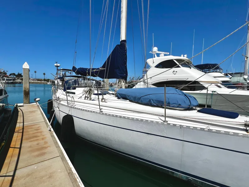 Slide: The Image of 1981 Cheoy Lee Golden Wave sailboat docked at marina under clear blue sky. - 3