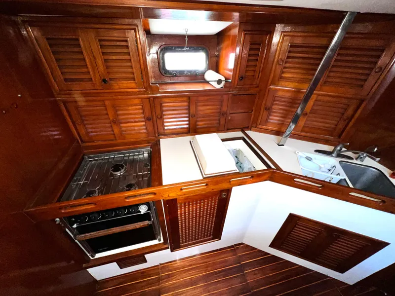 Slide: The Image of 1981 Cheoy Lee Golden Wave yacht kitchen with wooden cabinets and modern appliances. - 31