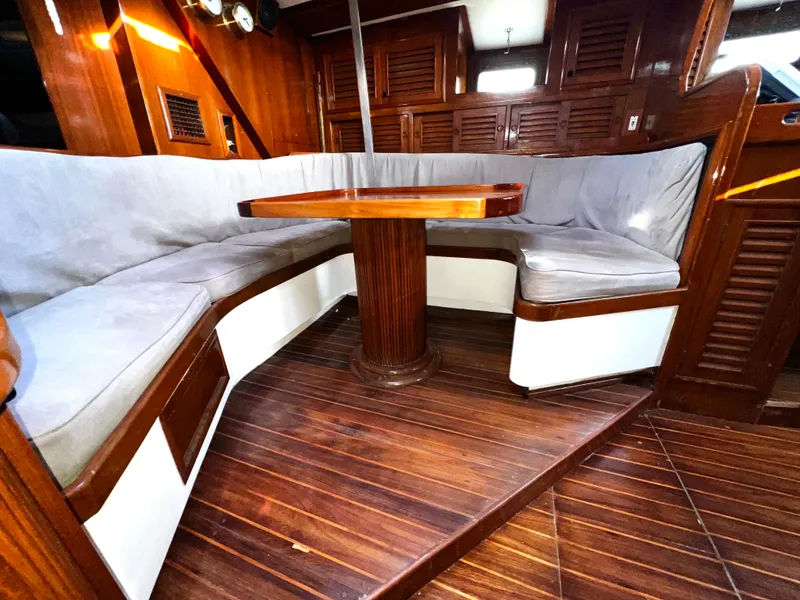 Slide: The Image of 1981 Cheoy Lee Golden Wave yacht interior with wooden flooring and cushioned seating area. - 32