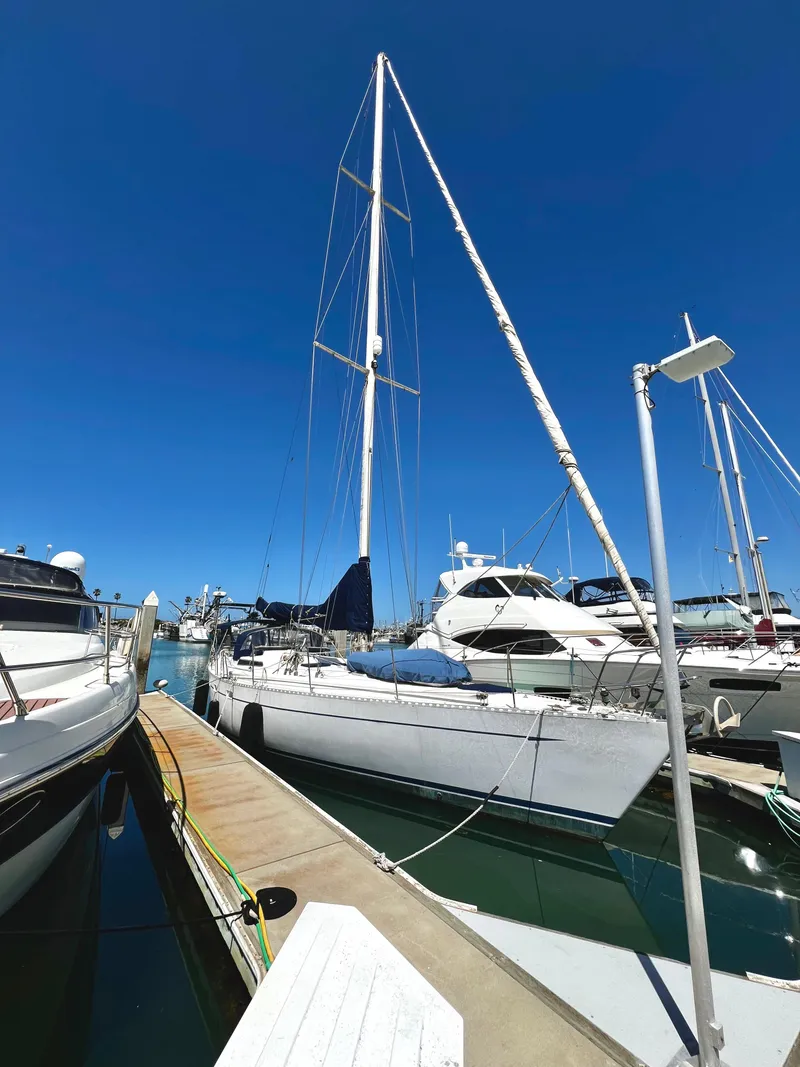 Slide: The Image of 1981 Cheoy Lee Golden Wave sailboat docked at marina under clear blue sky. - 4