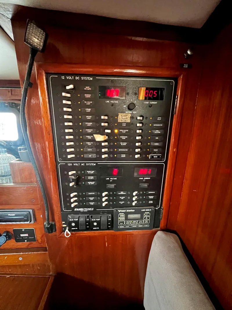 Slide: The Image of 1981 Cheoy Lee Golden Wave electrical panel with switches and meters in wooden interior. - 48