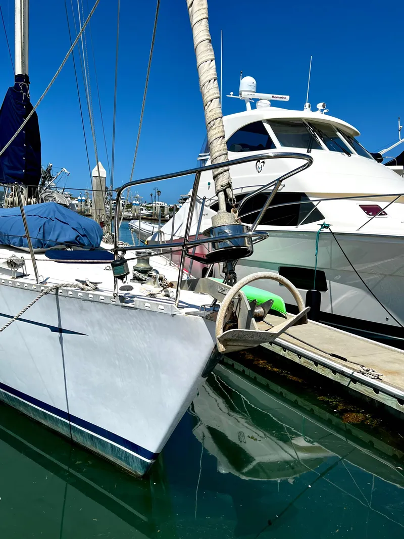 Slide: The Image of 1981 Cheoy Lee Golden Wave sailboat docked beside a motor yacht in a marina. - 6
