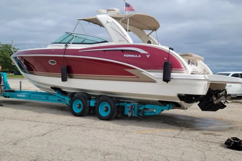 Slide: The Image of 2015 Formula 350 Sun Sport boat on trailer, red and white design, parked outdoors. - 2