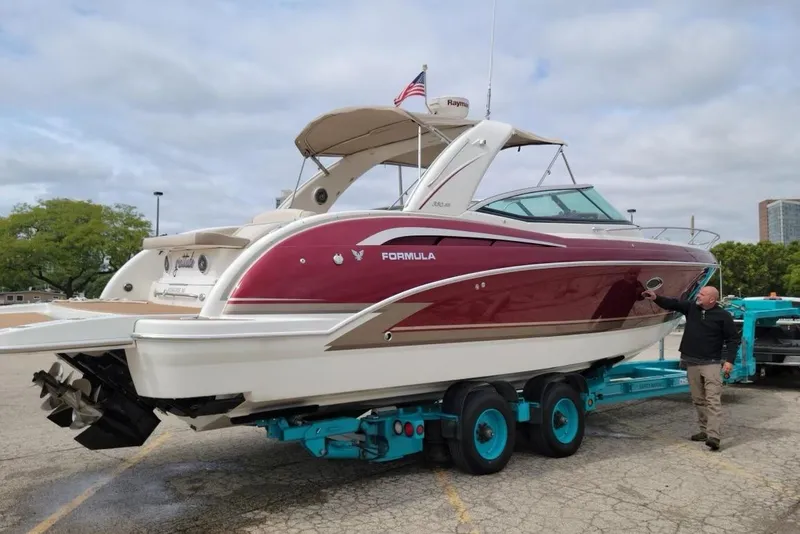 Slide: The Image of 2015 Formula 350 Sun Sport boat on trailer, red and white design, outdoors. - 3