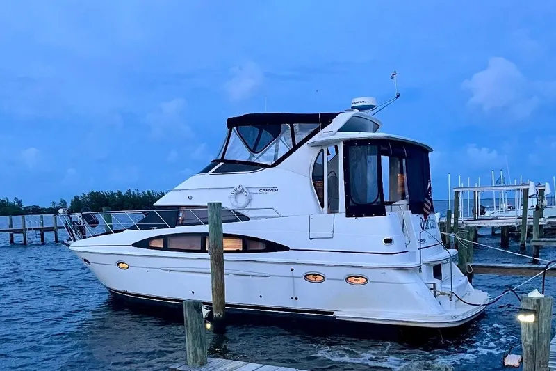The Image of 2001 Carver 396 Aft Cabin Motor Yacht docked at marina during twilight. - 1