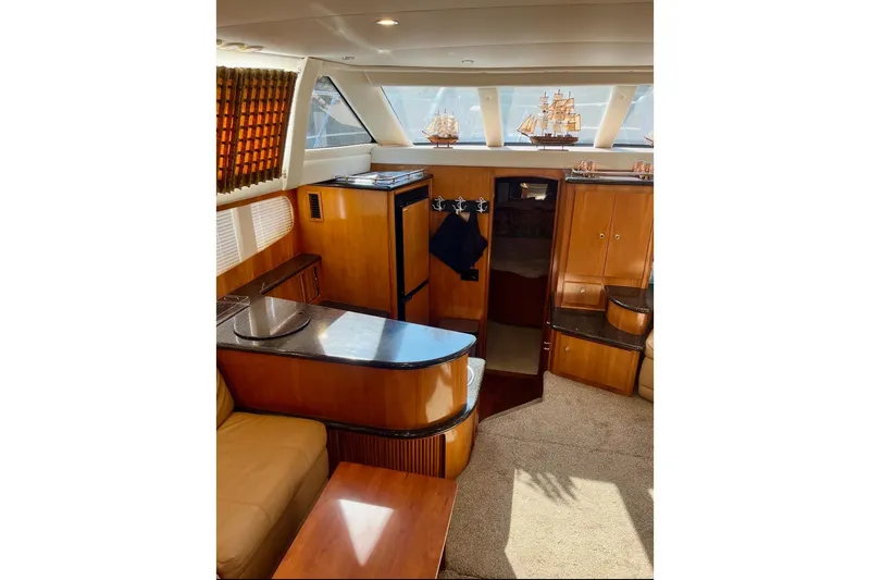 Slide: The Image of Luxurious interior of 2001 Carver 396 Aft Cabin Motor Yacht with wood finishes and model ships. - 13