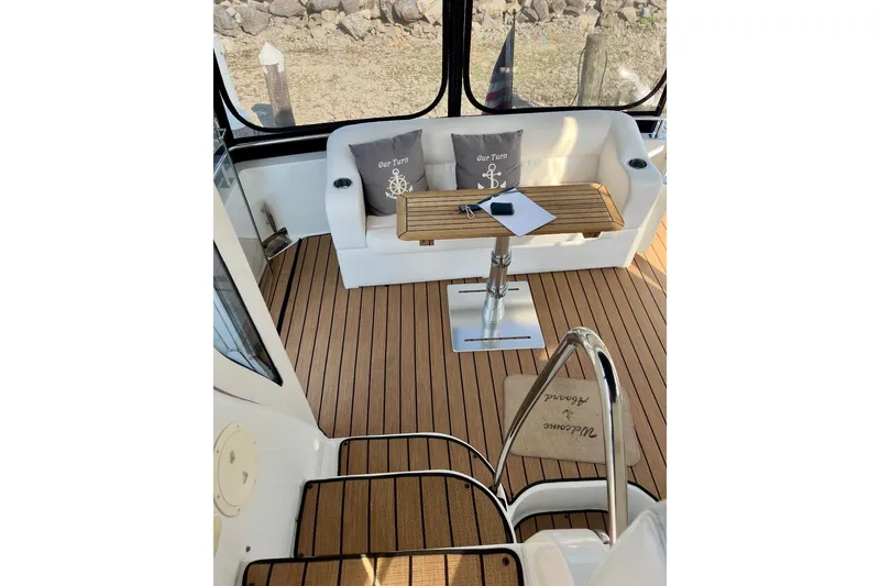 Slide: The Image of 2001 Carver 396 Aft Cabin Motor Yacht interior with teak flooring and cushioned seating. - 4