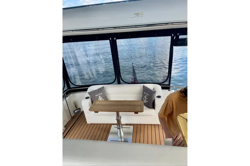 Slide: The Image of 2001 Carver 396 Aft Cabin Motor Yacht interior with seating and table, overlooking water. - 5