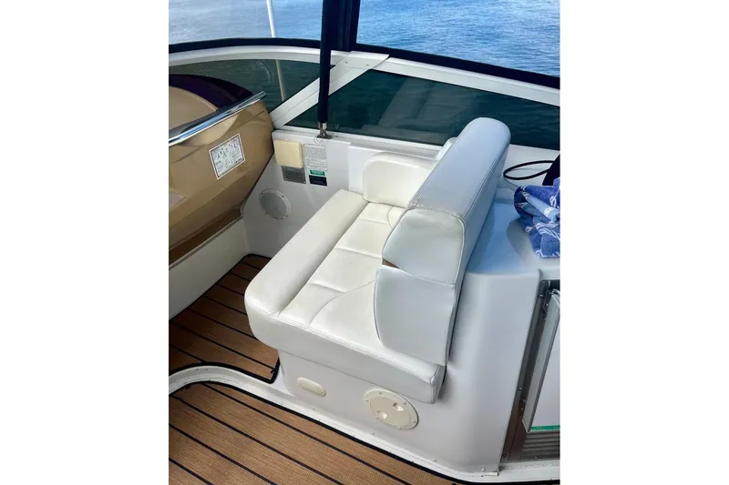 Slide: The Image of White seating area on 2001 Carver 396 Aft Cabin Motor Yacht, with wooden deck and water view. - 9
