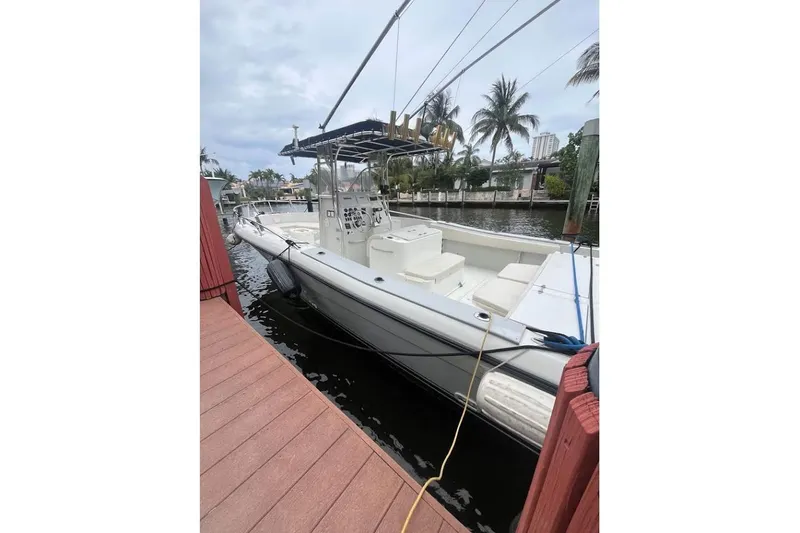 The Image of 1997 Stamas 290 Tarpon boat docked by palm trees and waterfront homes. - 0