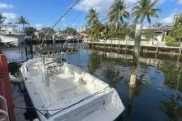 Slide: The Image of 1997 Stamas 290 Tarpon boat docked by palm trees and waterfront homes. - 1