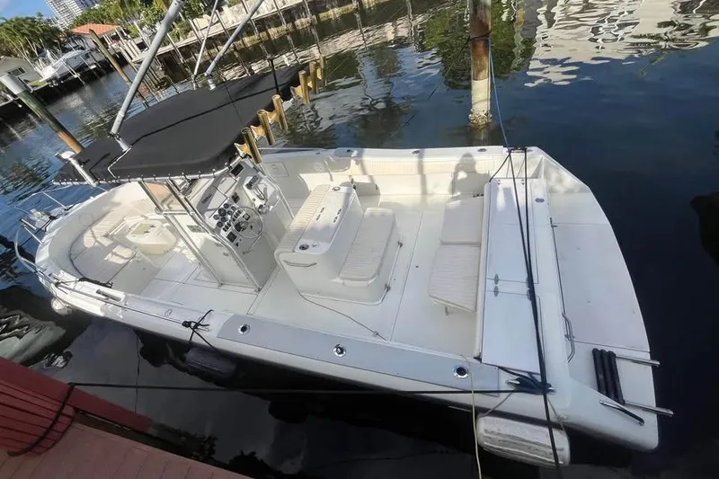 Slide: The Image of 1997 Stamas 290 Tarpon boat docked in a marina, featuring spacious seating and canopy. - 2