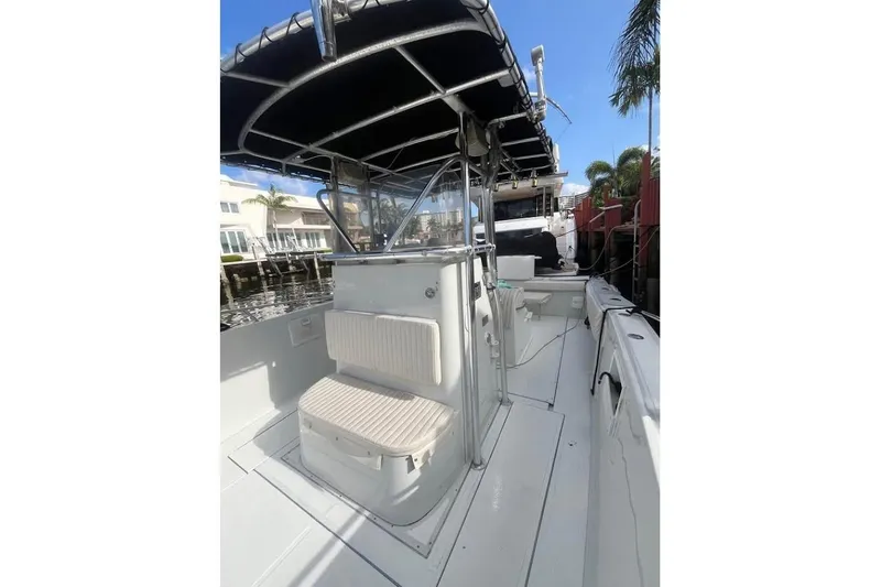 Slide: The Image of 1997 Stamas 290 Tarpon boat with canopy, docked near waterfront homes. - 5