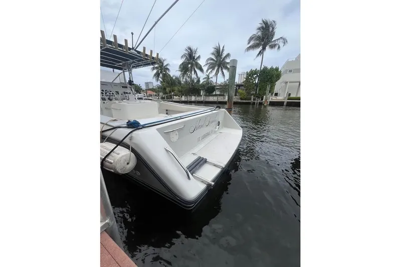 Slide: The Image of 1997 Stamas 290 Tarpon boat docked by palm trees and waterfront homes. - 6