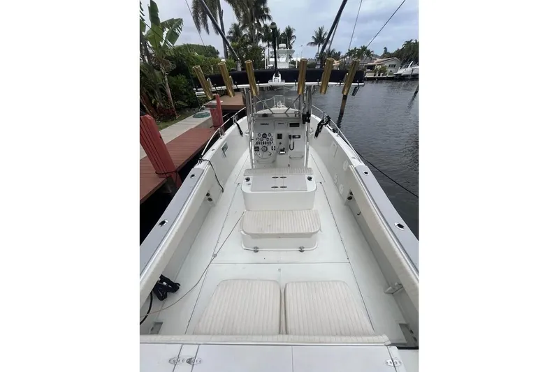 Slide: The Image of 1997 Stamas 290 Tarpon boat interior with seating and control panel, docked by the water. - 7