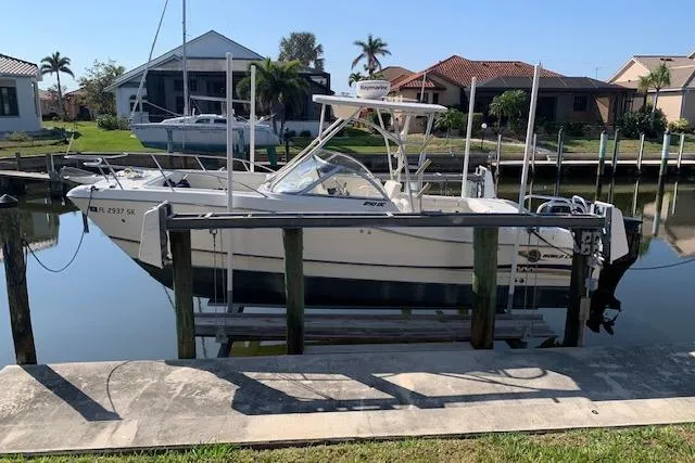 Slide: The Image of 2007 World Cat 250 DC boat docked in a residential canal setting. - 13
