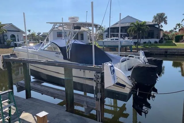 Slide: The Image of 2007 World Cat 250 DC boat docked in a residential canal setting. - 14