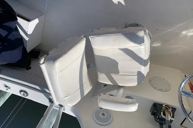 Slide: The Image of 2007 World Cat 250 DC boat interior with white seating and steering wheel. - 7