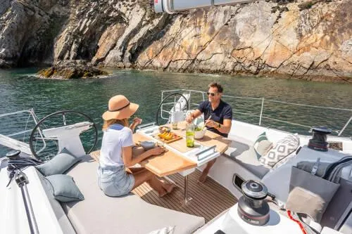 Slide: The Image of Couple dining on 2025 Beneteau Oceanis 37.1 yacht, scenic coastal backdrop. - 10