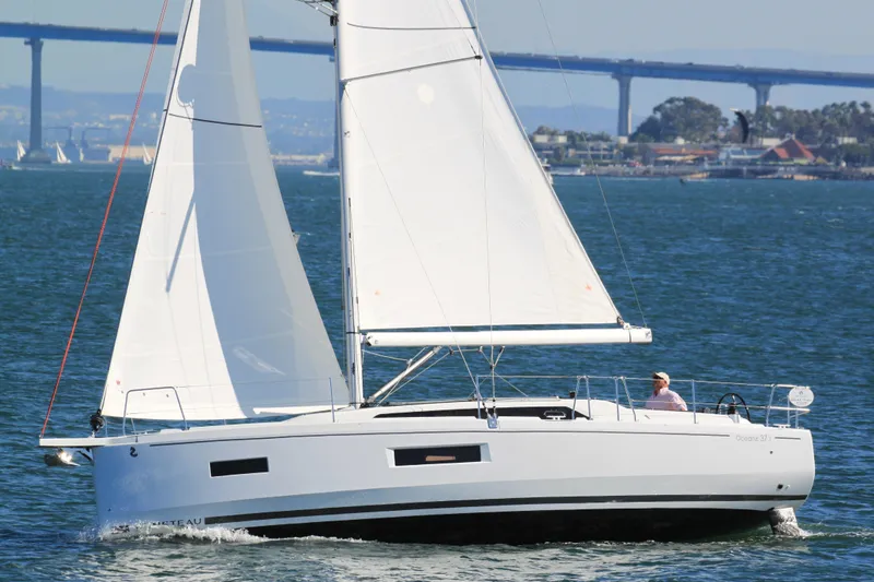 Slide: The Image of 2026 Beneteau Oceanis 37.1 sailing on open water with bridge in background. - 17
