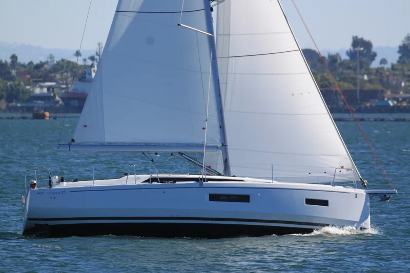 Slide: The Image of 2026 Beneteau Oceanis 37.1 sailing on a sunny day, showcasing sleek design and white sails. - 2