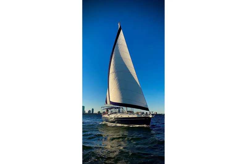 The Image of 2004 Beneteau 50 sailboat gliding on open water under clear blue sky. - 0