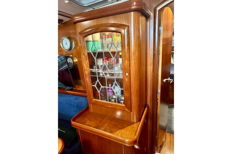 Slide: The Image of Luxurious wooden interior of a 2004 Beneteau 50 yacht with glass cabinet. - 10