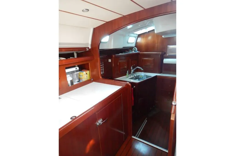 Slide: The Image of Interior of 2004 Beneteau 50 yacht, featuring elegant wood cabinetry and modern kitchen amenities. - 22