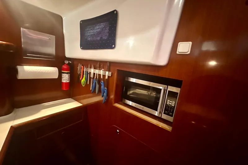 Slide: The Image of Galley of 2004 Beneteau 50 yacht with microwave, tools, and fire extinguisher. - 26