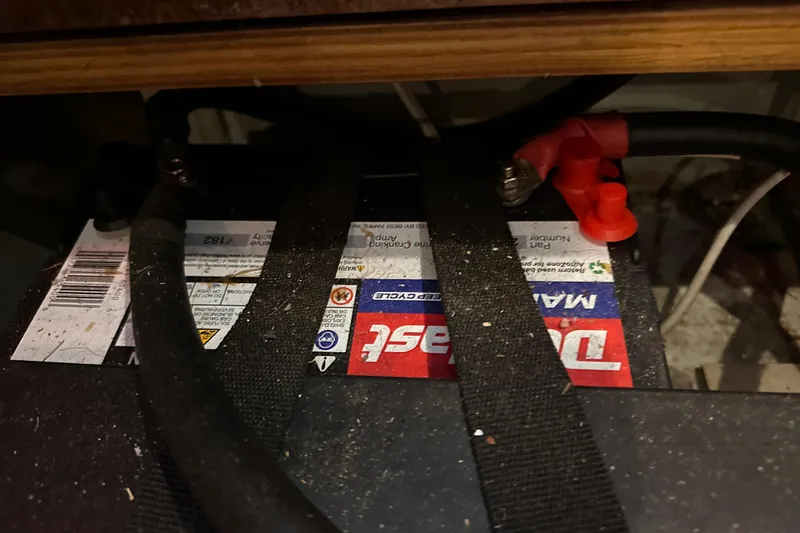 Slide: The Image of Battery compartment of a 2004 Beneteau 50 sailboat, featuring a secured marine battery. - 32