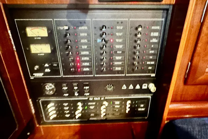Slide: The Image of Control panel of a 2004 Beneteau 50 yacht, featuring various switches and gauges. - 37